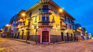 A multi-story building with a prominent entrance, balconies, and a sign indicating a business establishment. - Hotel Boutique Los Balcones (Cuenca)