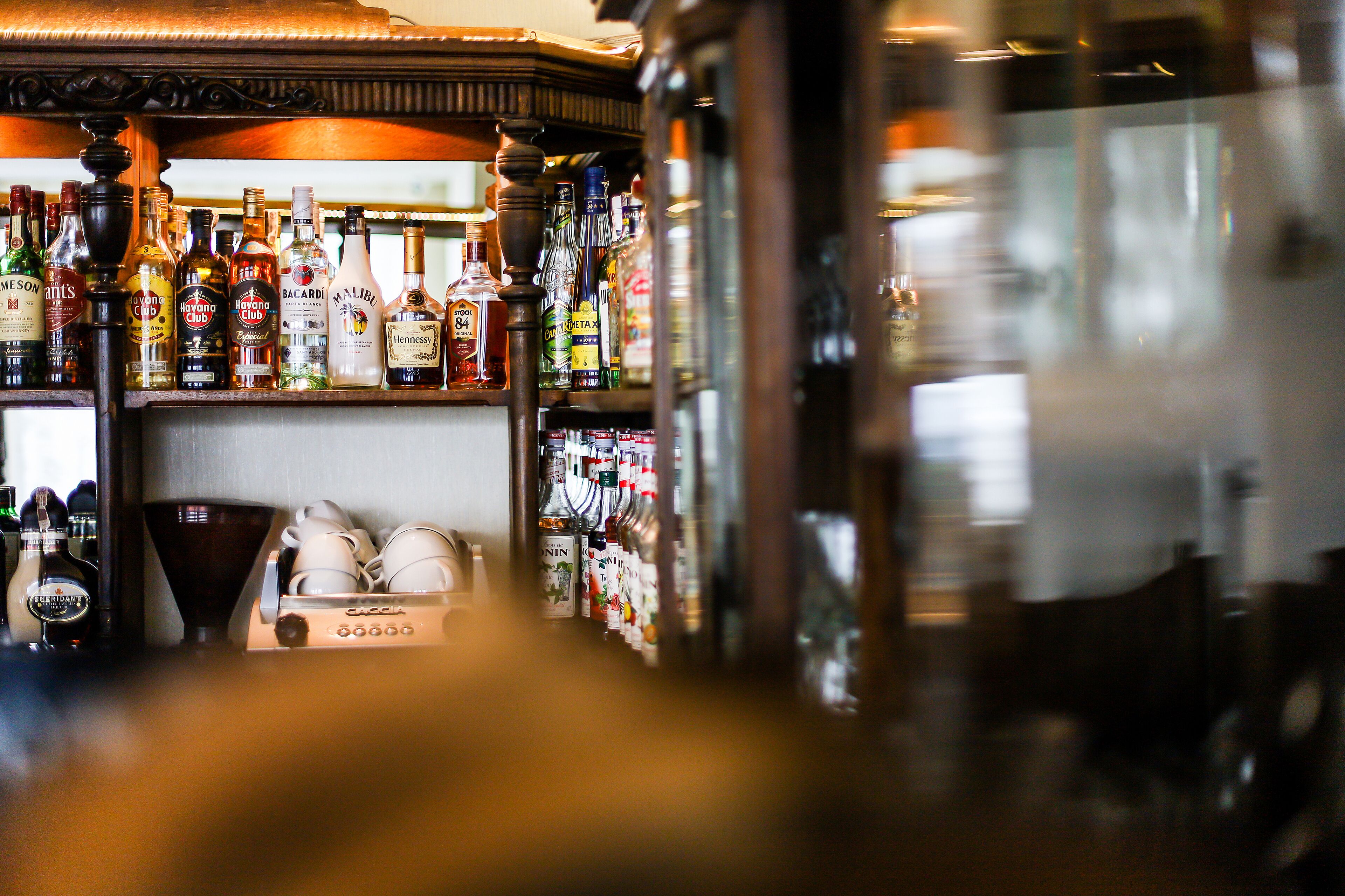 Eine Bar mit verschiedenen Spirituosenflaschen und einer Kaffeemaschine.