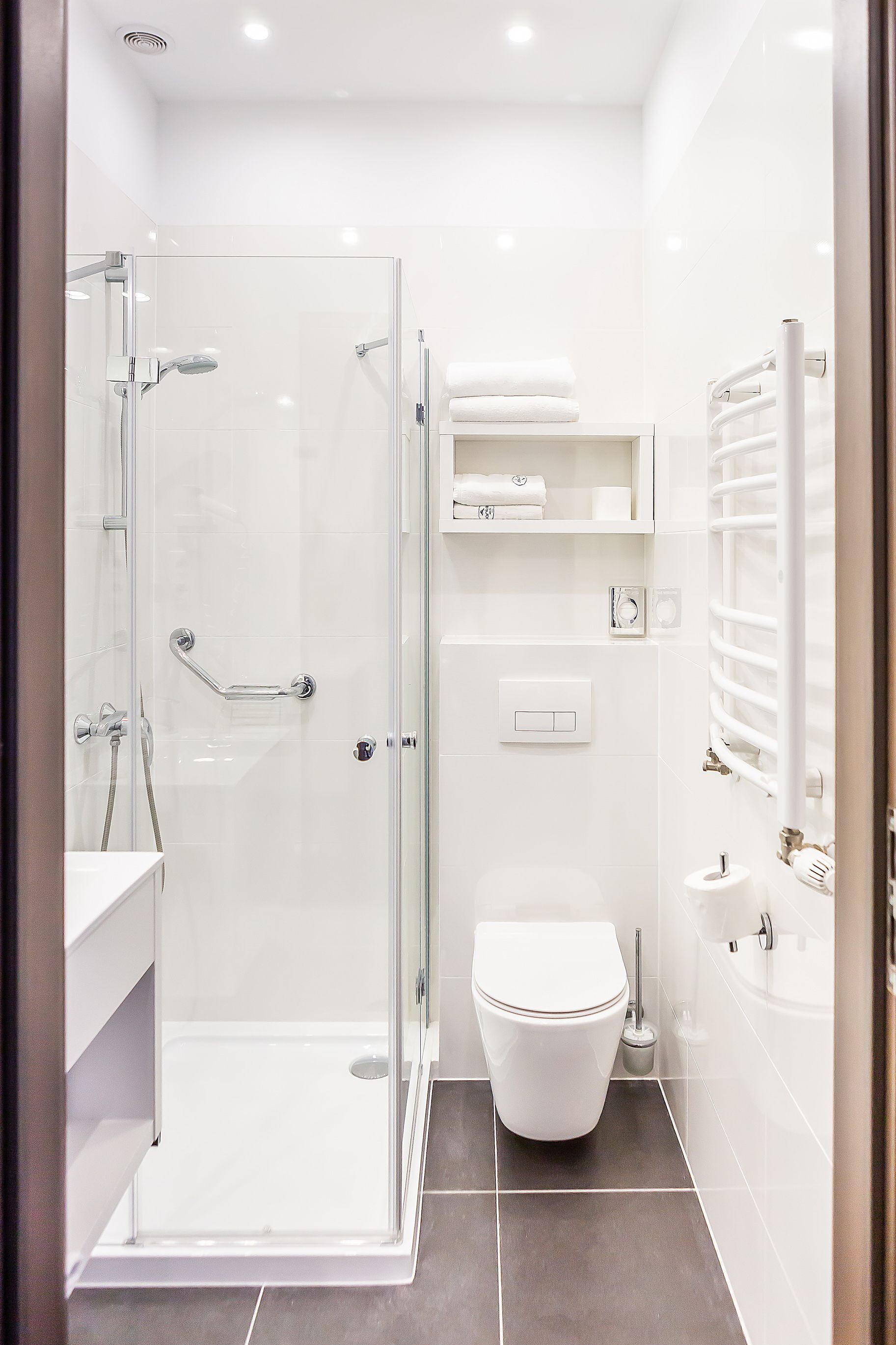 A modern bathroom with a glass-enclosed shower, a toilet, and a bathtub.
