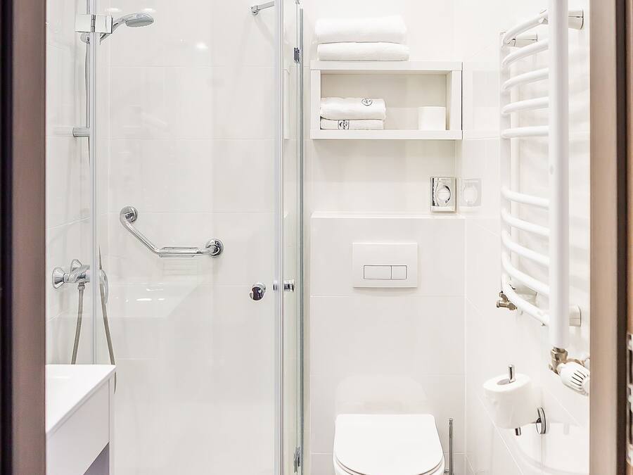 A modern bathroom with a glass-enclosed shower, a toilet, and a bathtub.
