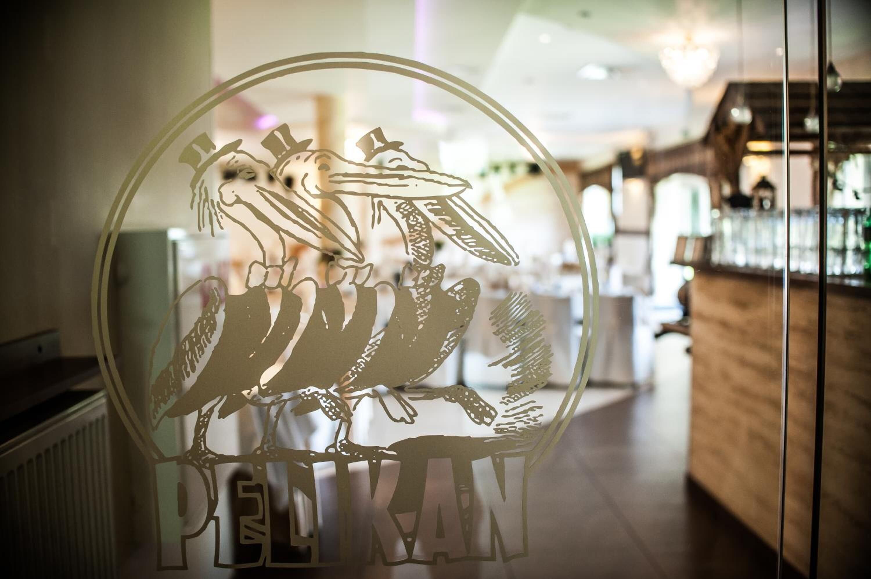 Una puerta de cristal con un diseño de pájaro y la palabra "PELATAN" escrita en ella.