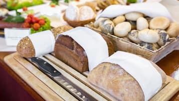 Une variété de pains et de viennoiseries présentés sur une planche en bois.