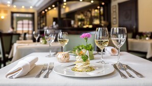 A restaurant table set with white tablecloth, silverware, and a dessert. - Bukowy Park Hotel Medical Spa (Polanica-Zdroj)