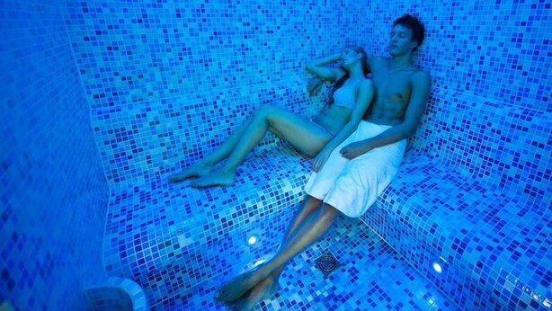 A person lying in a bathtub with mosaic tiles. - Bukowy Park Hotel Medical Spa (Polanica-Zdroj)