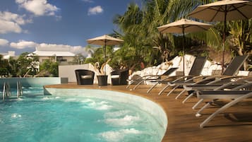 Una piscina al aire libre, sombrillas, tumbonas