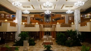 Eine prachtvolle Lobby mit Marmorböden, mehreren Ebenen und aufwendigen Kronleuchtern.