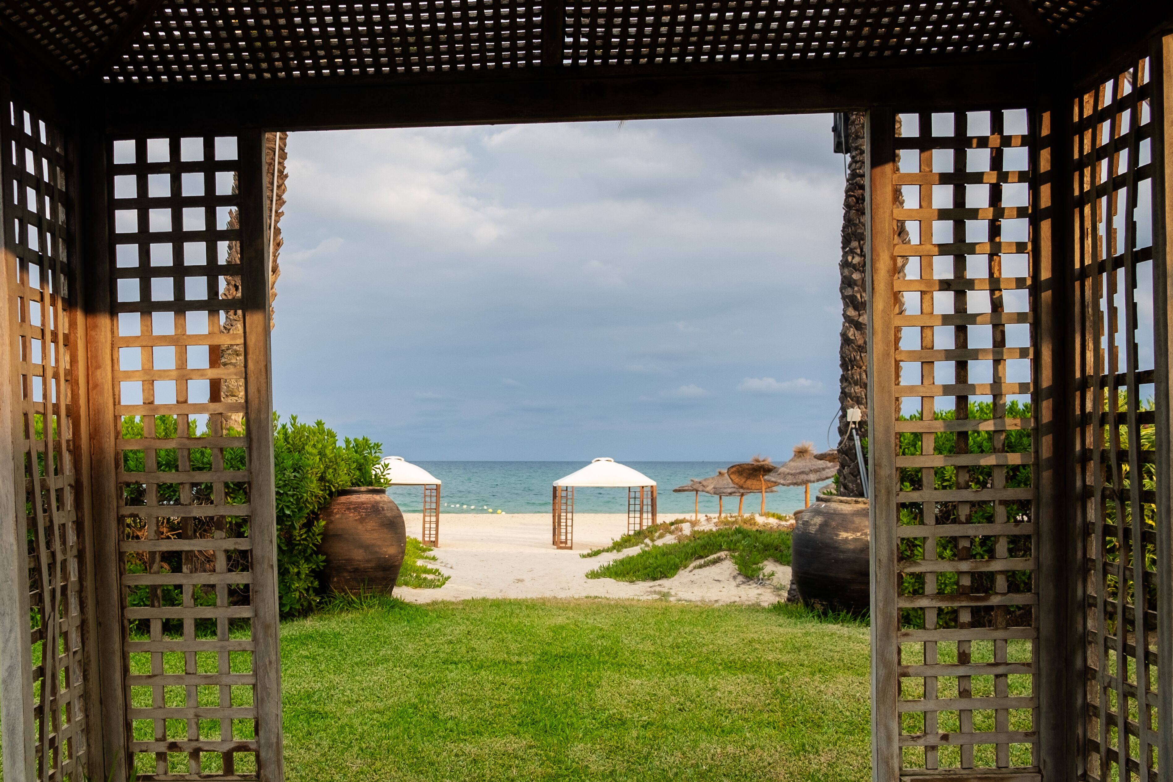 Rannalla, aurinkotuoleja, aurinkovarjoja, rantapyyhkeitä