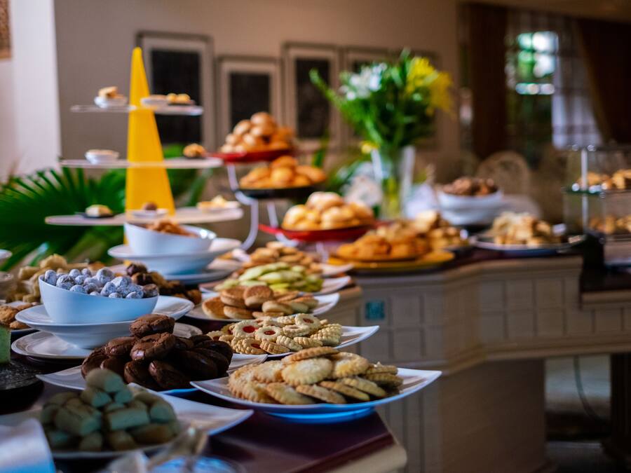 Una mesa de buffet con diversos alimentos y un cono amarillo decorativo.