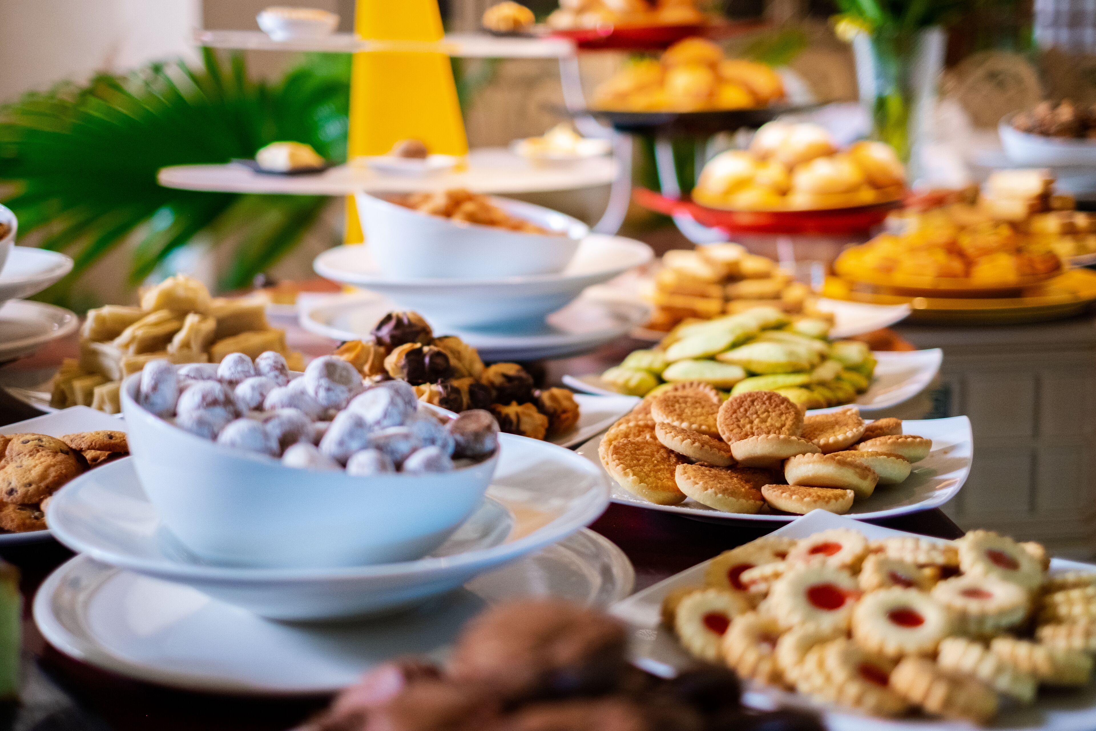 A buffet with various food items including cookies, pastries, and a bowl of chocolate-covered treats.