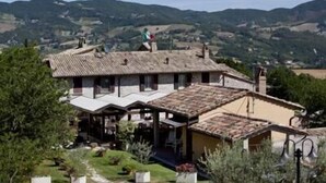 A traditional villa with a tiled roof, a covered porch, and a garden. - Il Castello (Assisi)