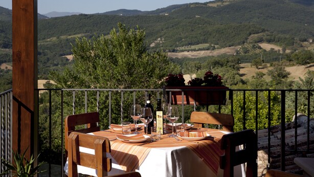 A table set for dining with a view of rolling hills. - Il Castello (Assisi)