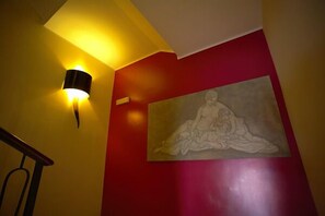 Una scala con un punto luce a parete e un quadro di grandi dimensioni.