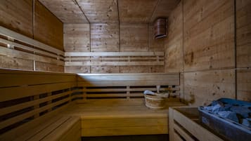 Uma sauna de madeira com bancos e um balde.