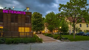 Entrada de un hotel con un camino empedrado, una valla de madera y un letrero que dice "BETEKINTS".