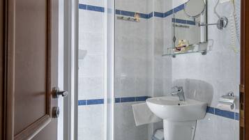 Une salle de bain avec une douche à parois de verre, un lavabo et des toilettes.
