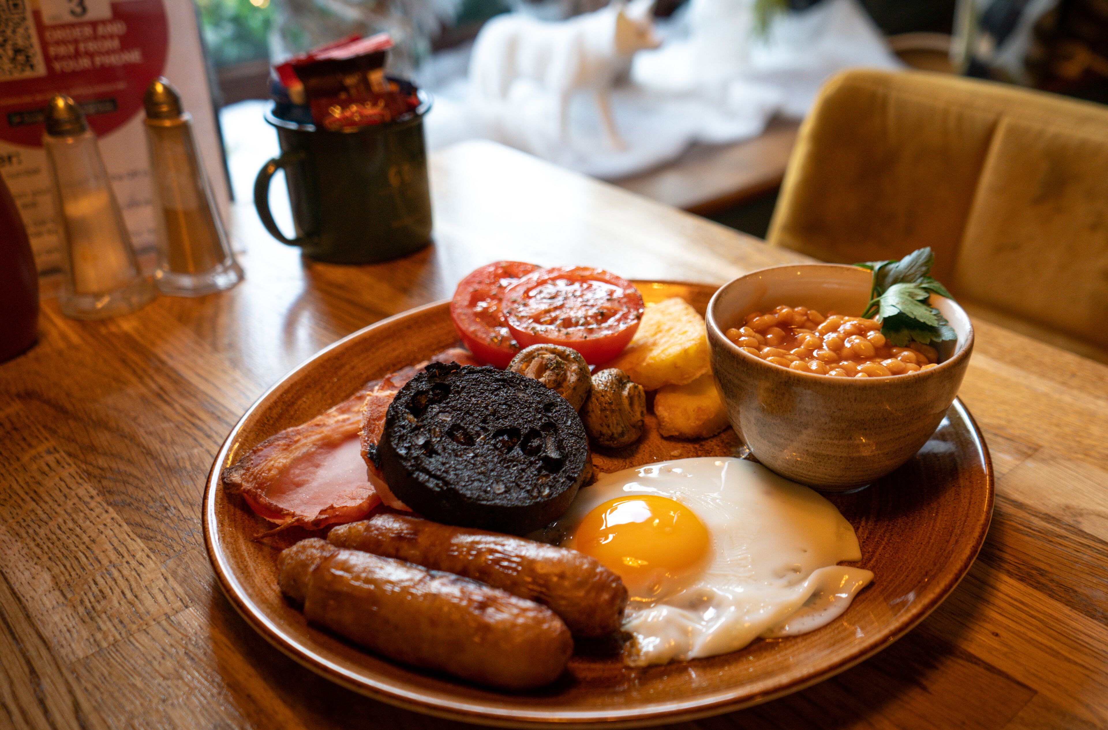 A breakfast plate with eggs, sausages, tomatoes, beans, and toast.