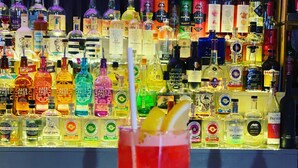 Un bar con una variedad de botellas de licor al fondo.