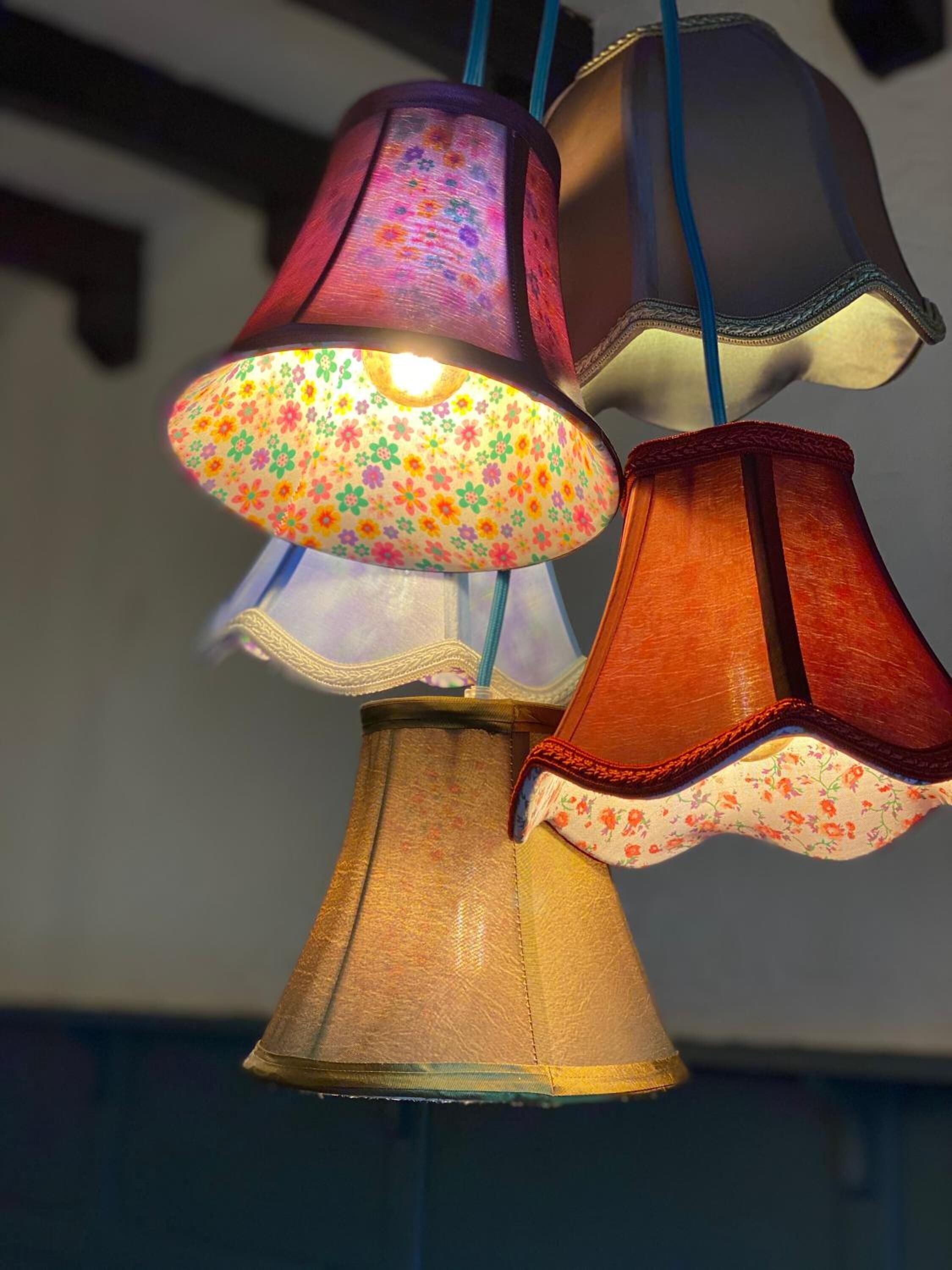 Varias lámparas colgantes con diseños florales y detalles de madera.