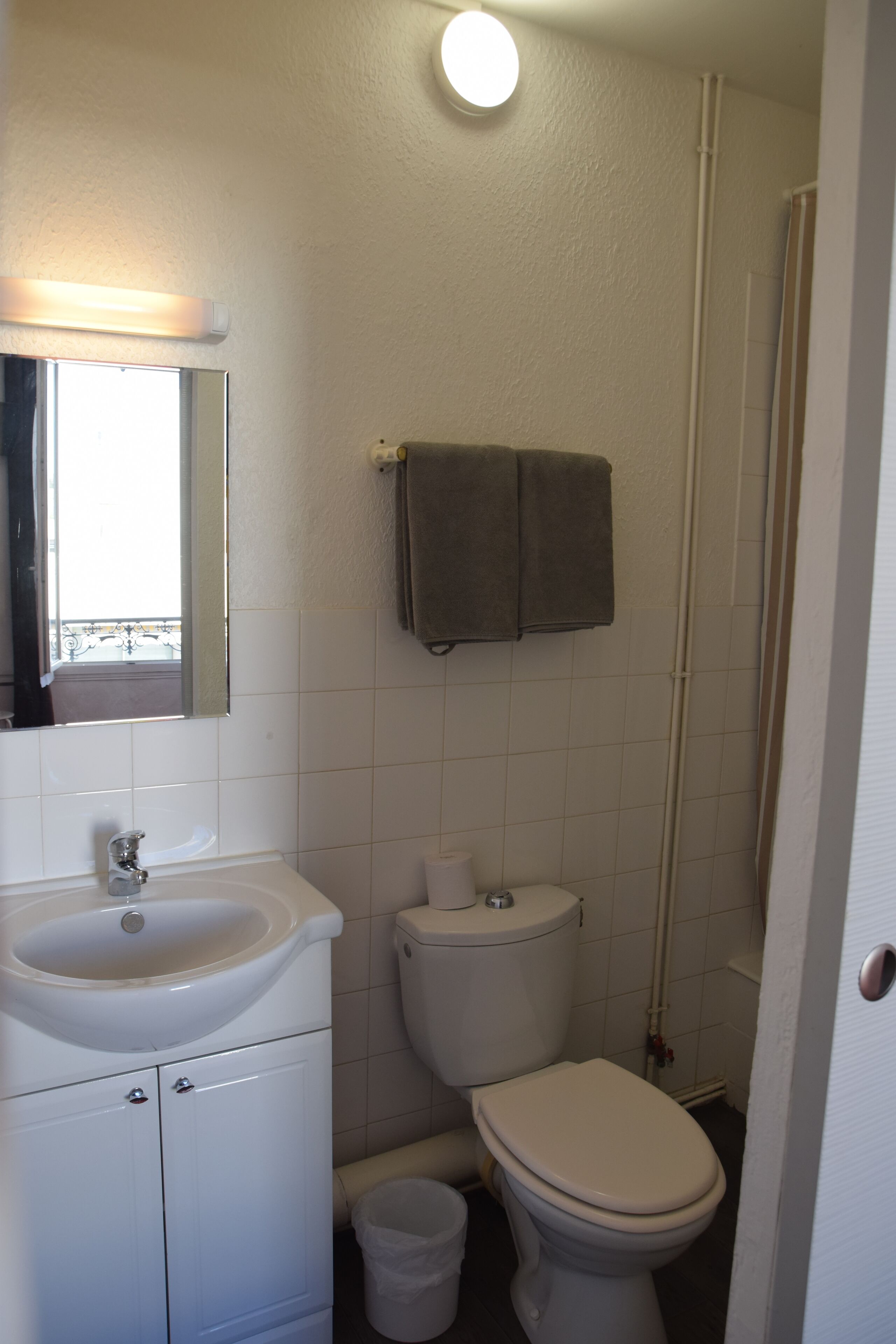 Un baño con lavamanos, inodoro y zona de ducha.