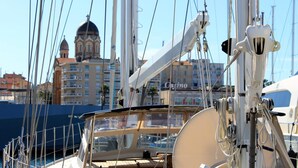 Uma marina com barcos atracados, um edifício com cúpula em destaque ao fundo, e um letreiro de cassino visível.