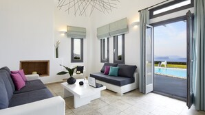 Ein modernes Wohnzimmer mit einer Couch, einem Couchtisch mit einem Laptop und Blick auf einen Pool durch große Fenster.