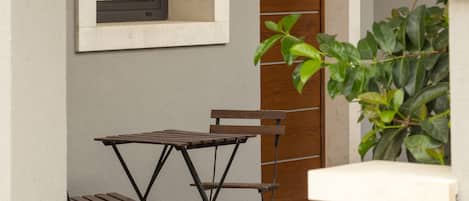 A patio with a table and chairs, a window, and a door.
