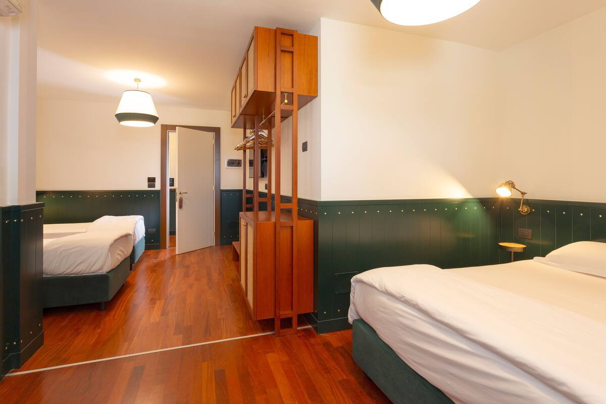 Una habitación de hotel con dos camas, muebles de madera y una cama de estilo loft singular.
