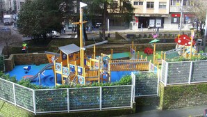 A playground with slides, climbing structures, and a fenced area. - Hostal Residencia Fornos (Santiago de Compostela)