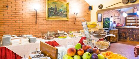 Un bufé con distintos alimentos y una pared de ladrillo con un cuadro enmarcado.