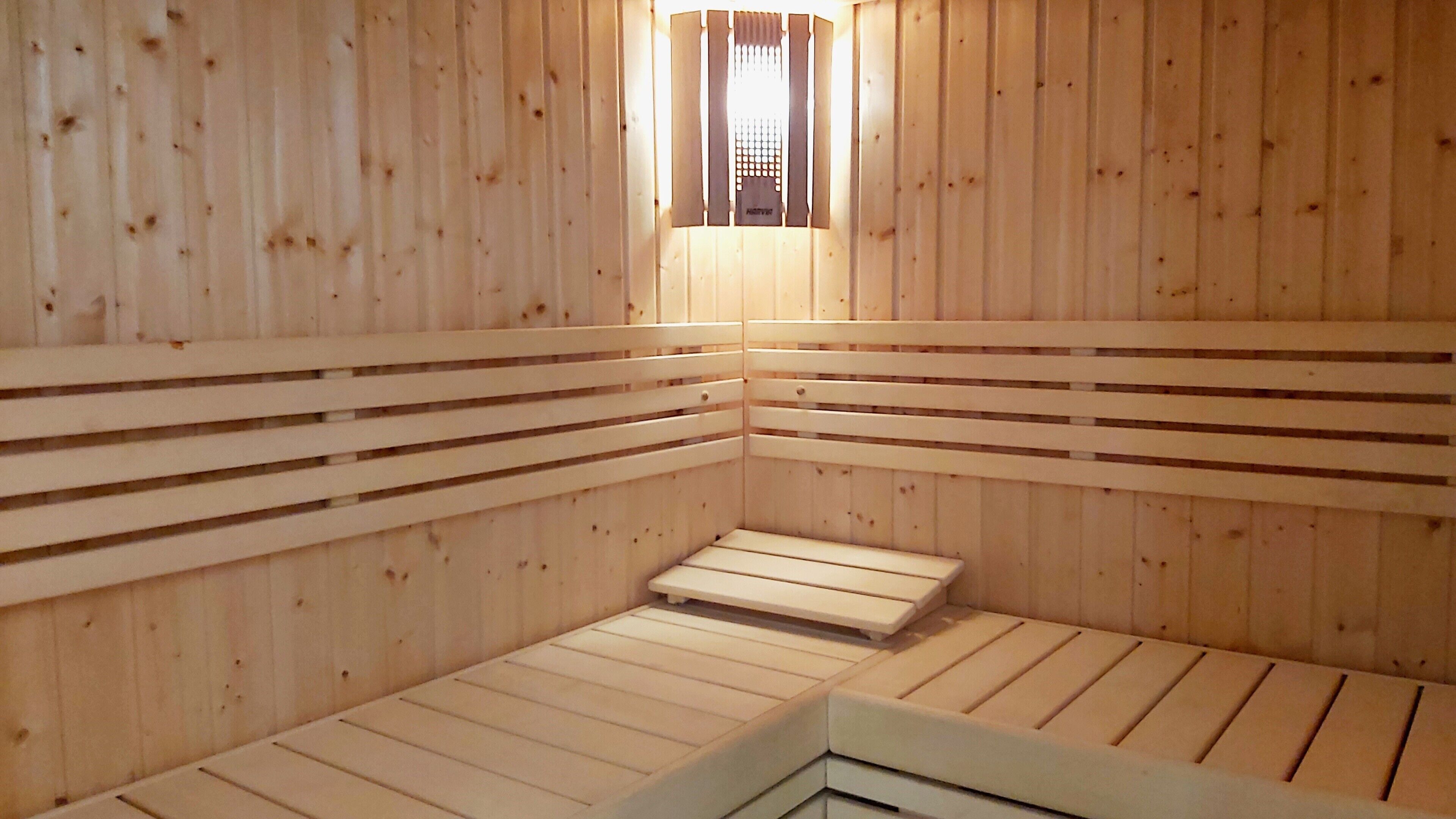 Un sauna avec des murs et des bancs en bois.