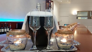 Eine Bar mit zwei Weissweingläsern, einer Champagnerflasche und zwei Gläsern mit dem Aufdruck 'Kroglis' auf einem Tablett.