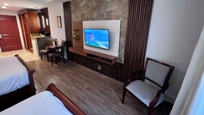 A hotel room with a bed, a desk with a chair, a television mounted on the wall, and a view of a mountainous landscape. - Hotel Valle del Rio, SA (Boquete)