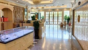 A spacious lobby with a reception desk, a chandelier, and a large display case. - Vienna Hotel (Shenzhen Bijiashan Yinhu subway station) (Shenzhen)