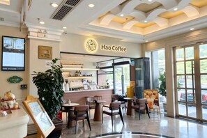 A coffee shop interior with a counter, seating area, and a large window. - Vienna Hotel (Shenzhen Bijiashan Yinhu subway station) (Shenzhen)