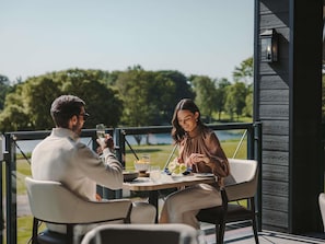 A dining area with a table, chairs, and a view of the outdoors. - Fairmont Cheshire The Mere (Knutsford)