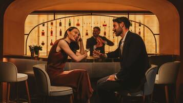 A bar area with a curved wall, bar stools, and a bartender.