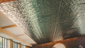 A spa area with a large indoor pool, a circular wall feature, and a seating area with a small table. - Fairmont Cheshire The Mere (Knutsford)