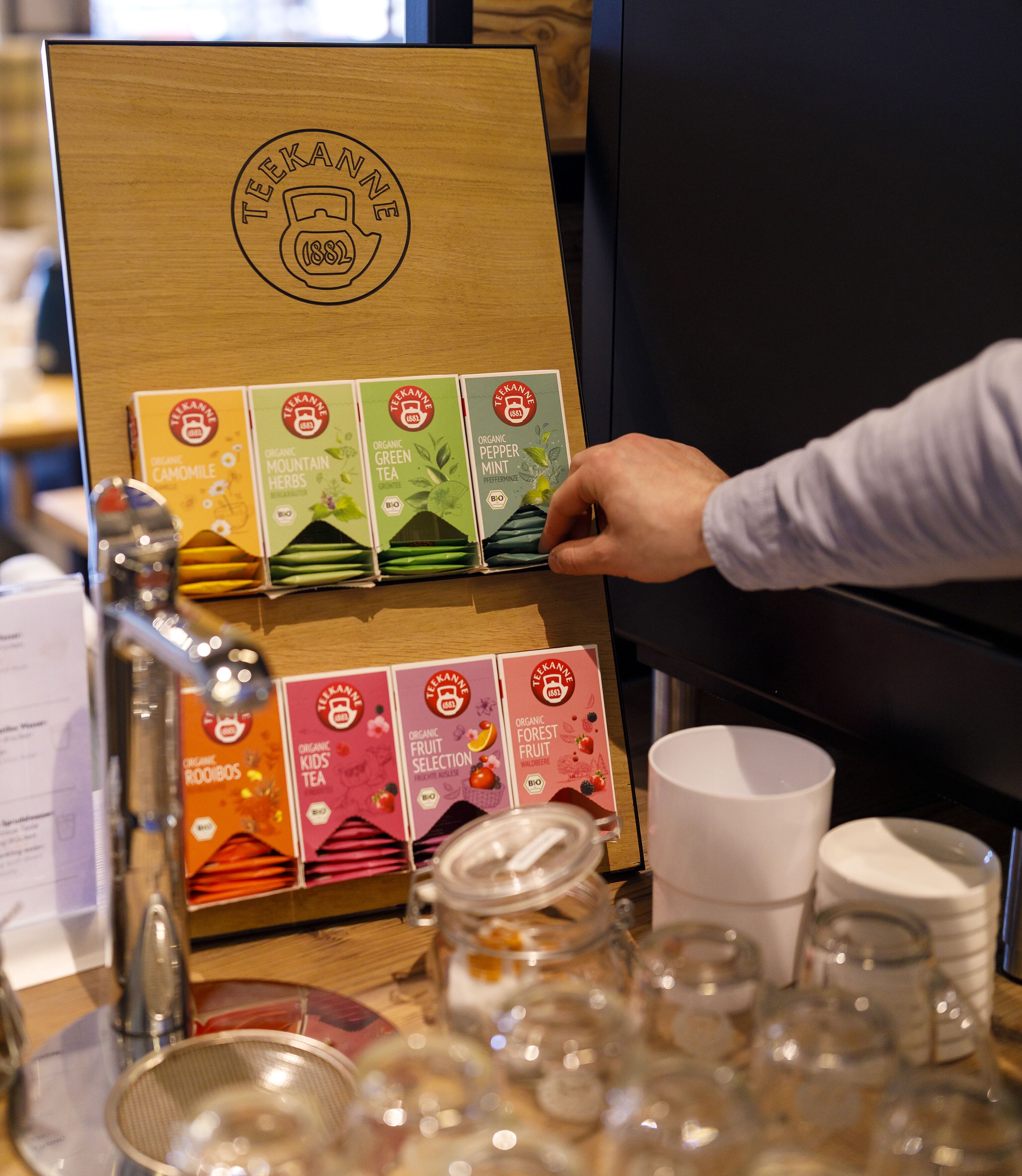 Exhibición de cajas de té orgánico con un letrero de madera encima.
