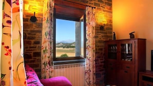 A room with a window, a radiator, a wooden cabinet, and a book on a table. - Casa Pirineo, Ainsa (Ainsa)