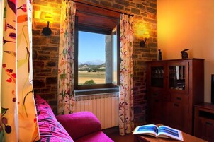 Una habitación con ventana, un radiador, un armario de madera y un libro sobre una mesa.