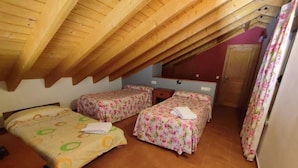 A room with two beds, a wooden ceiling, and a red wall. - Casa Pirineo, Ainsa (Ainsa)