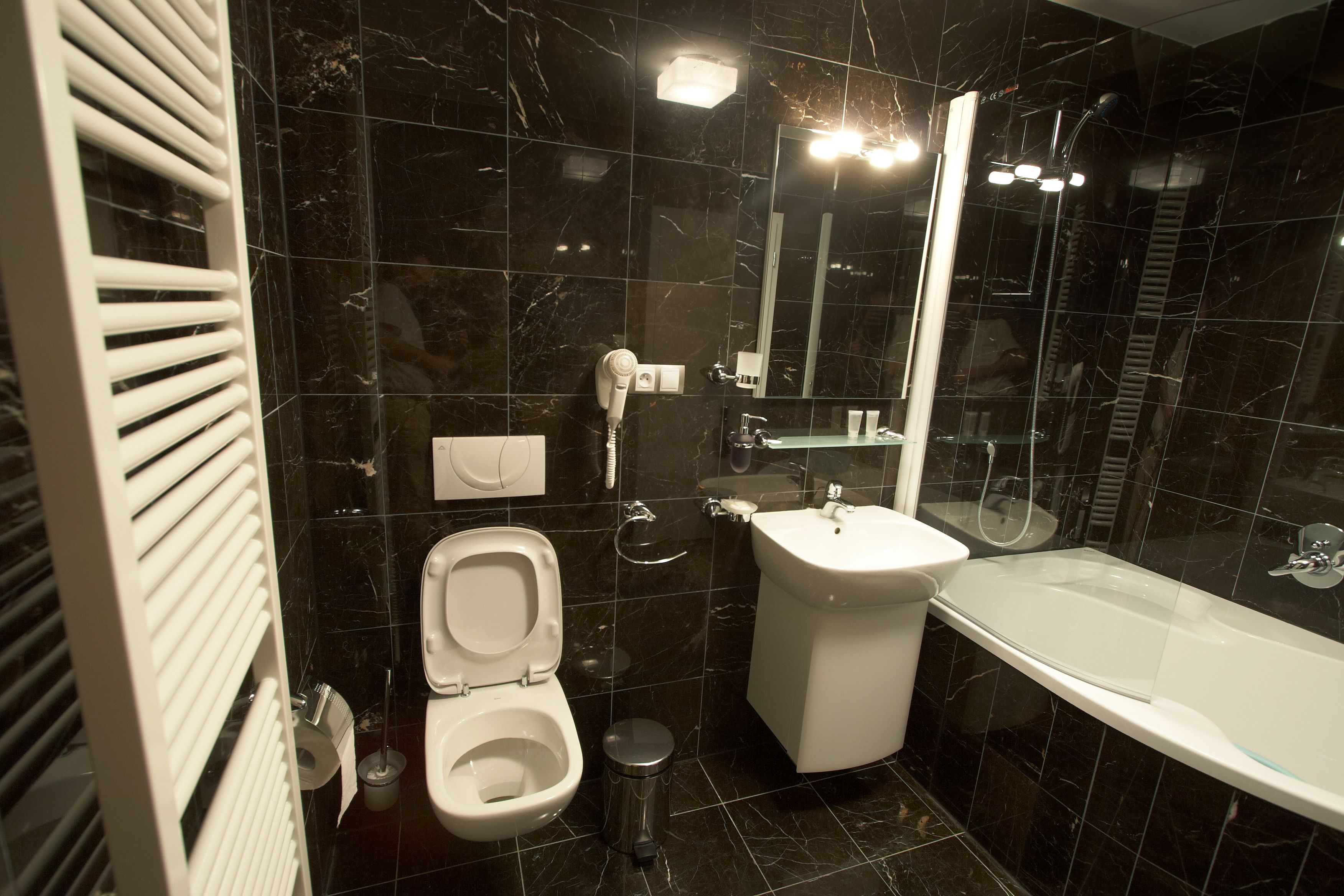 Een moderne badkamer met toilet, bidet, wastafel en bad.