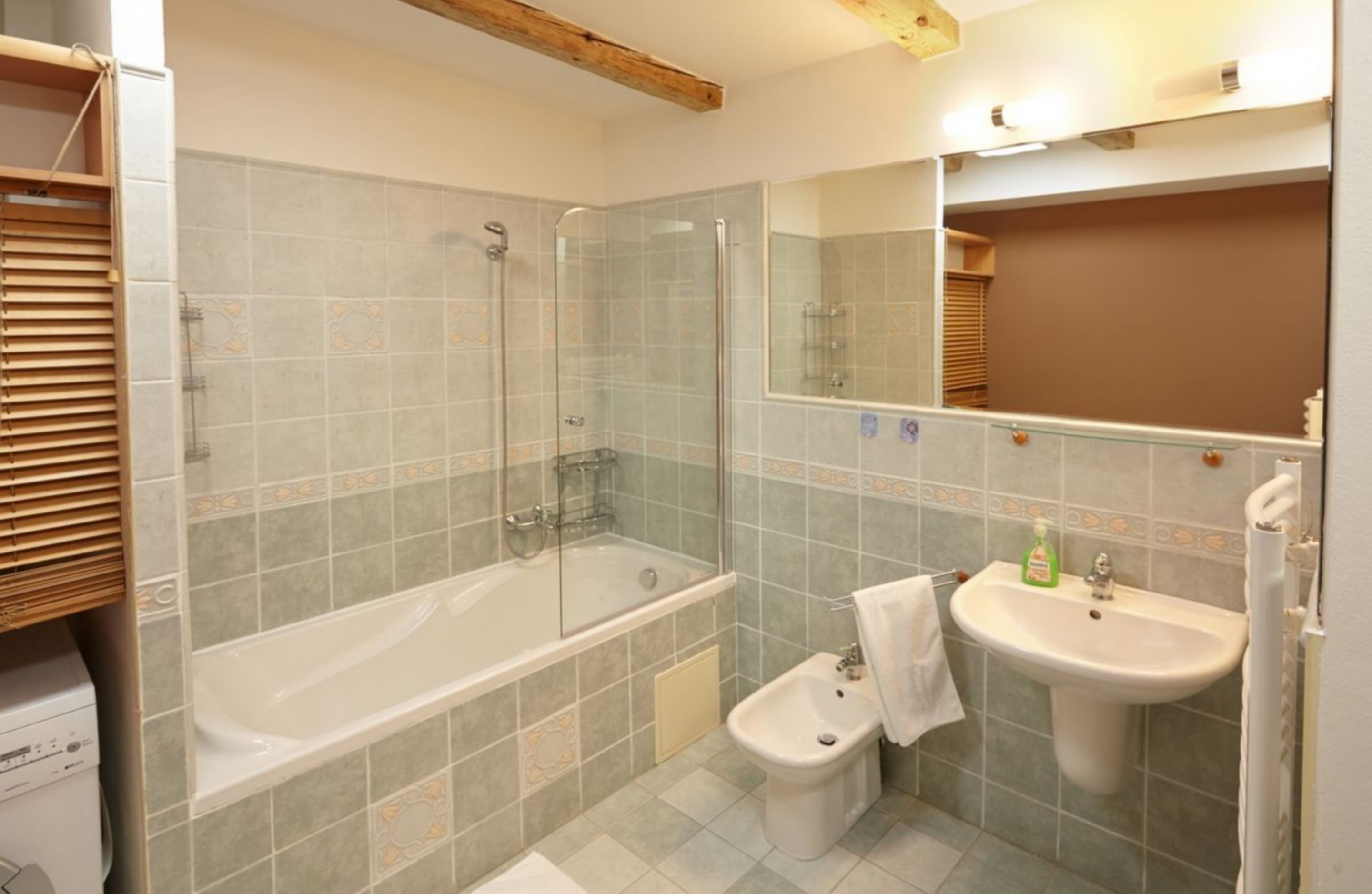 Une salle de bain équipée d’une baignoire, d’une douche, d’un bidet et d’un lavabo.