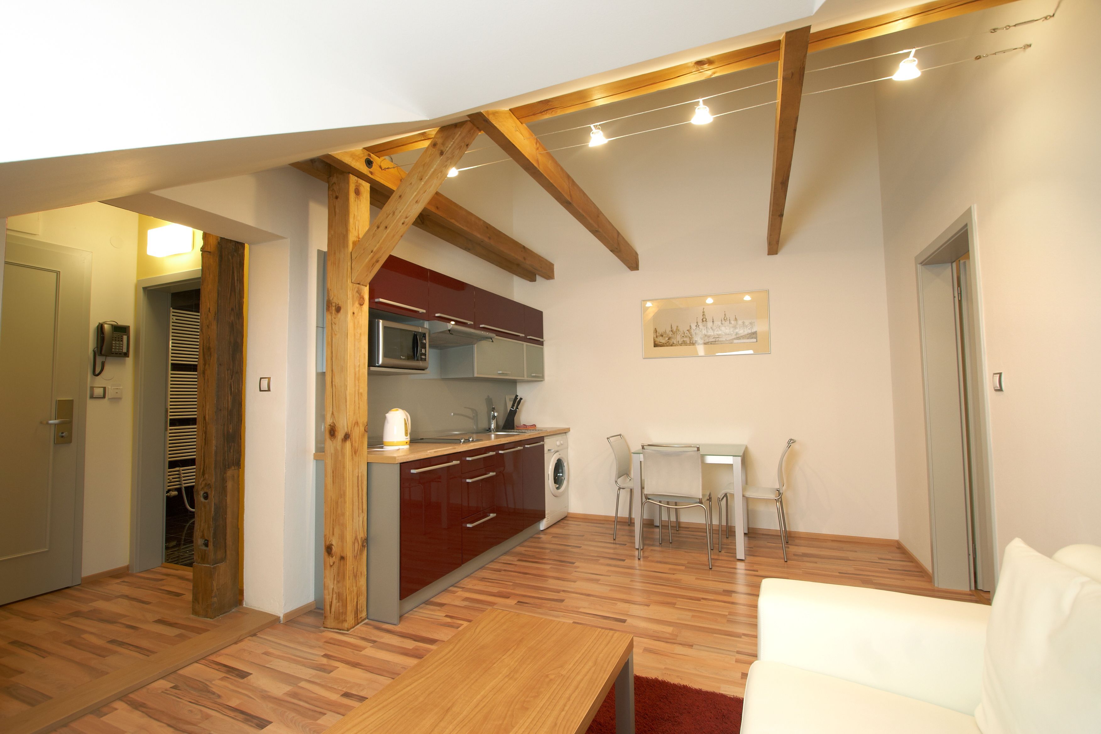 Un espacio habitable compacto con cocina, comedor y un sofá blanco.
