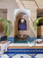 Una vasca idromassaggio con pavimento piastrellato, un arco decorativo e una persona che si rilassa nell'acqua.