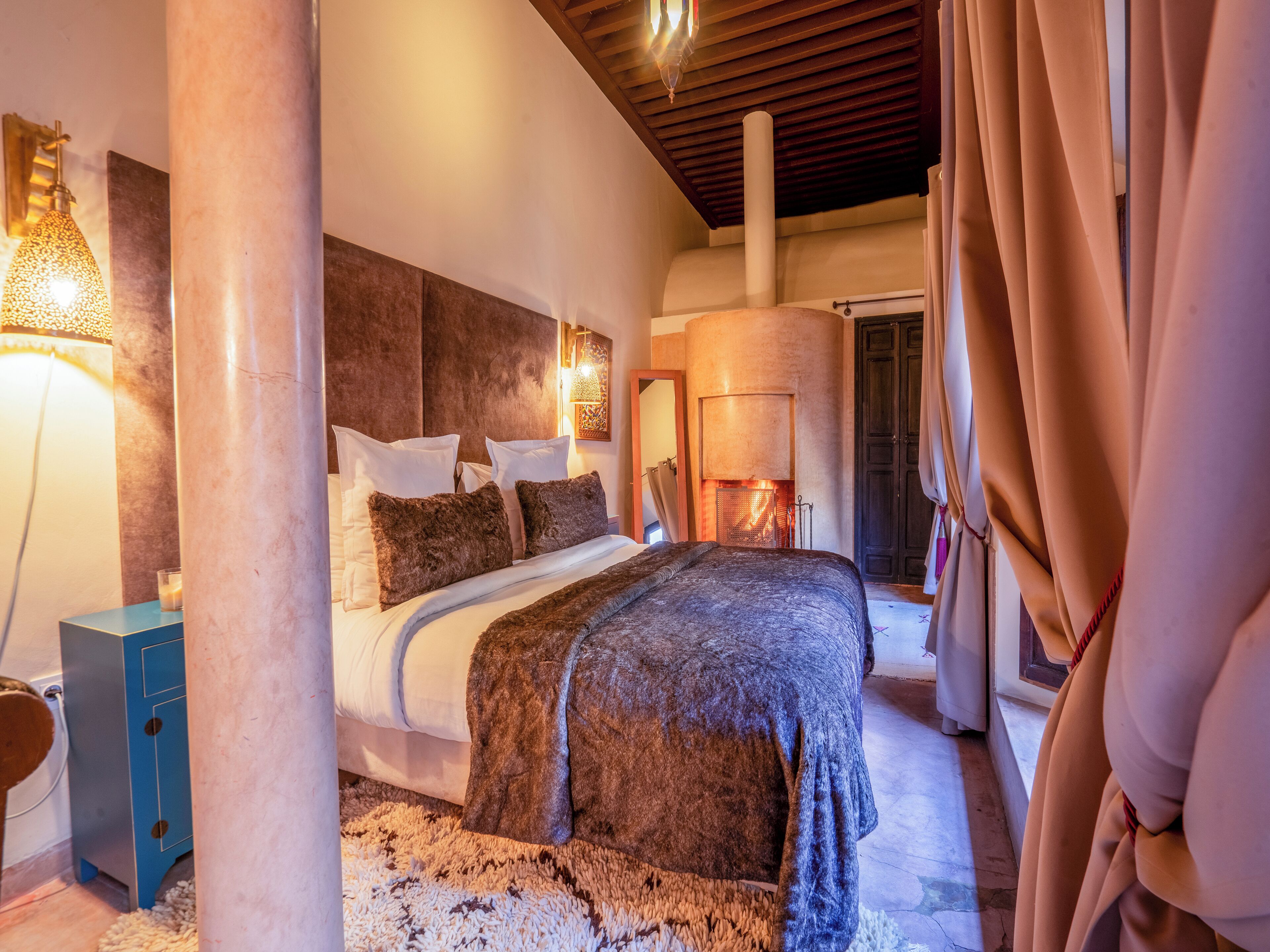 Un dormitorio con una cama grande, una chimenea y vistas al exterior.