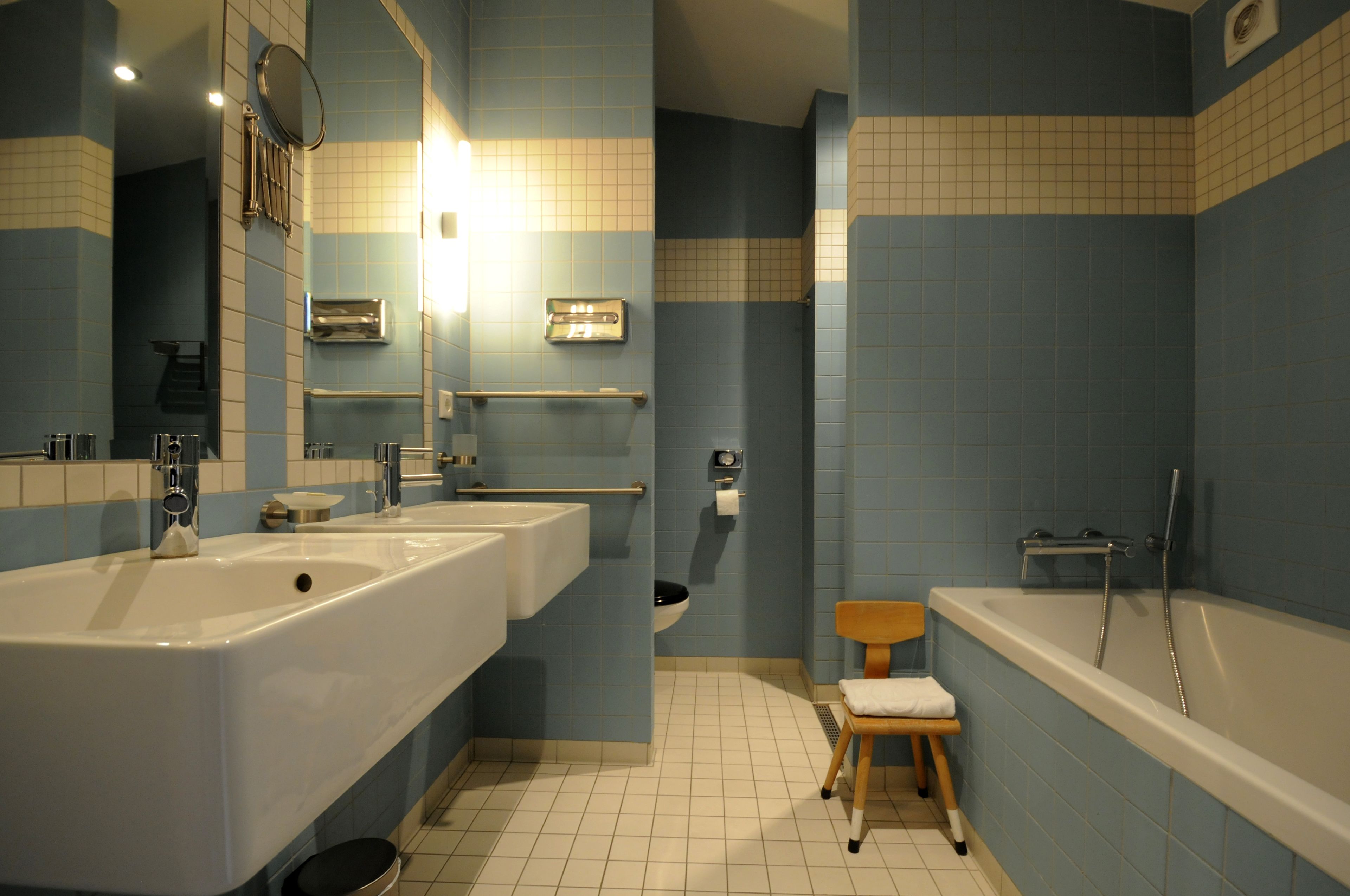 A bathroom with two sinks, a toilet, a shower, and a mirror.