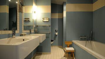 A bathroom with two sinks, a toilet, a shower, and a mirror.