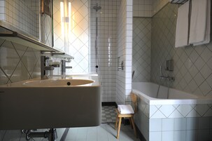 Un baño con un lavamanos grande, una ducha y una bañera.