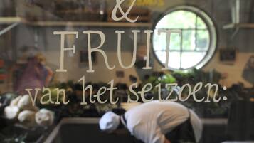 Een kraampje met het bordje 'Groente & Fruit van het seizoen'.